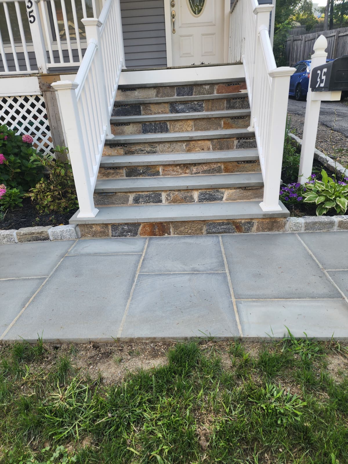 Bluestone front steps with natural stone risers and a matching bluestone walkway