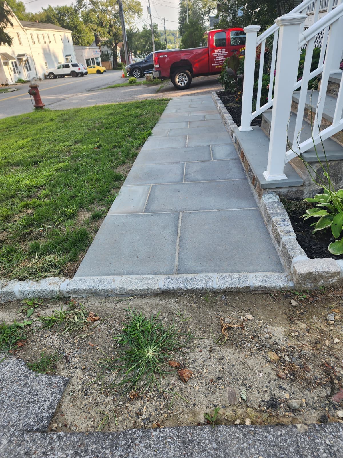 Bluestone sidewalk with Belgian block edging along a residential street